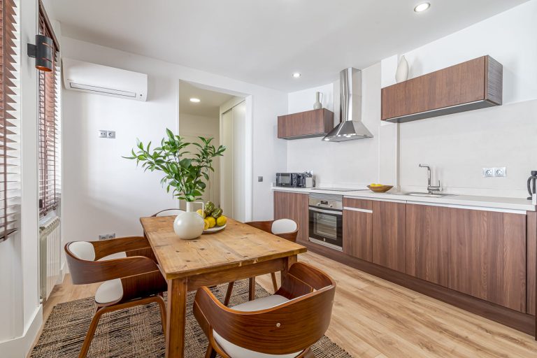 Cocina reformada y comedor de una vivienda turística en la calle Arriaza, junto al Palacio Real de Madrid.