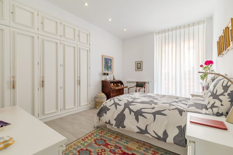 Dormitorio con balcón de una vivienda reformada y vendida en la calle Barbieri, barrio de Justicia, Madrid.